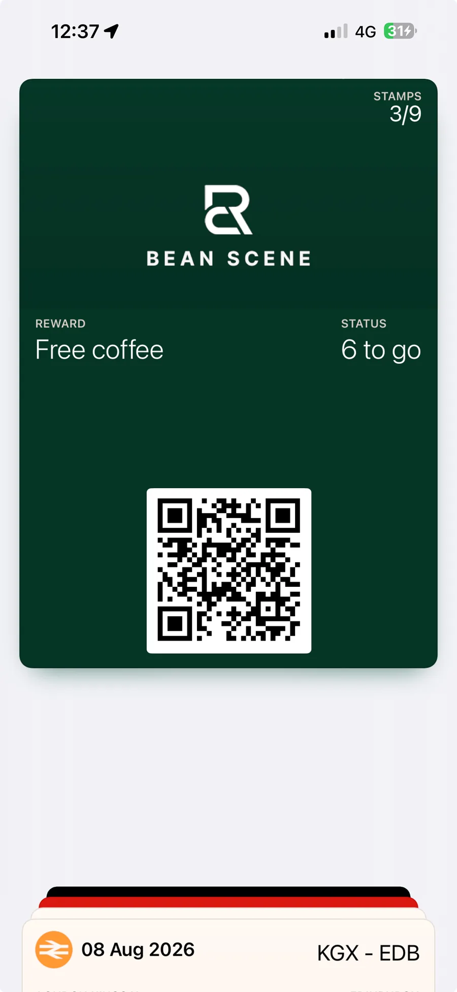 A Bean Scene loyalty card open in Apple Wallet on an iPhone: 3 of 9 stamps collected, 6 to go until a free coffee, and the QR code the barista scans. Another pass, a train ticket, sits behind it in the same wallet.